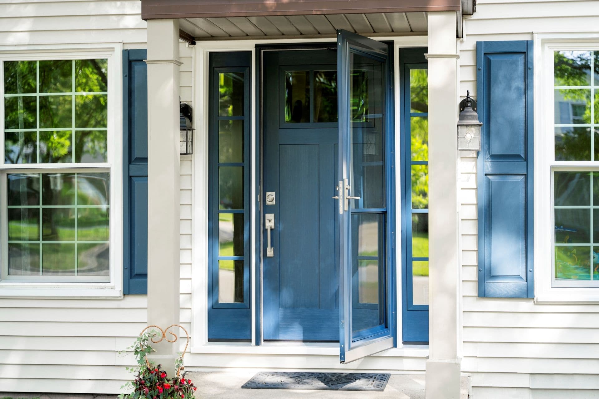 A blue Signet Fir Colonial front entry door with side lites and a door lite with a grid.